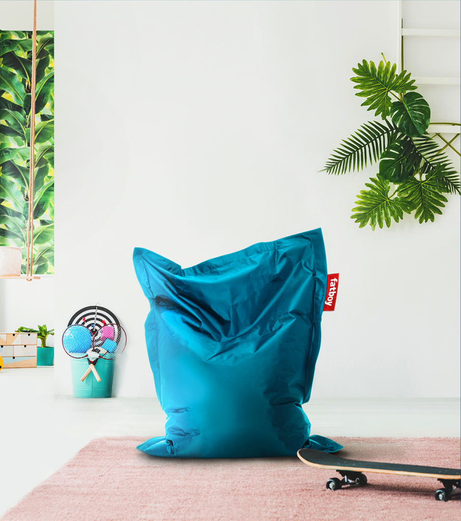 Un fauteuil poire bleu dans une pièce avec une planche à roulettes.