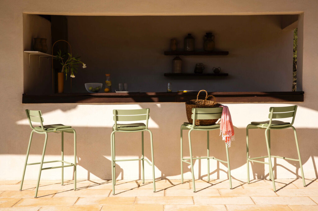 Un groupe de tabourets verts Chaise haute Luxembourg devant un bar.