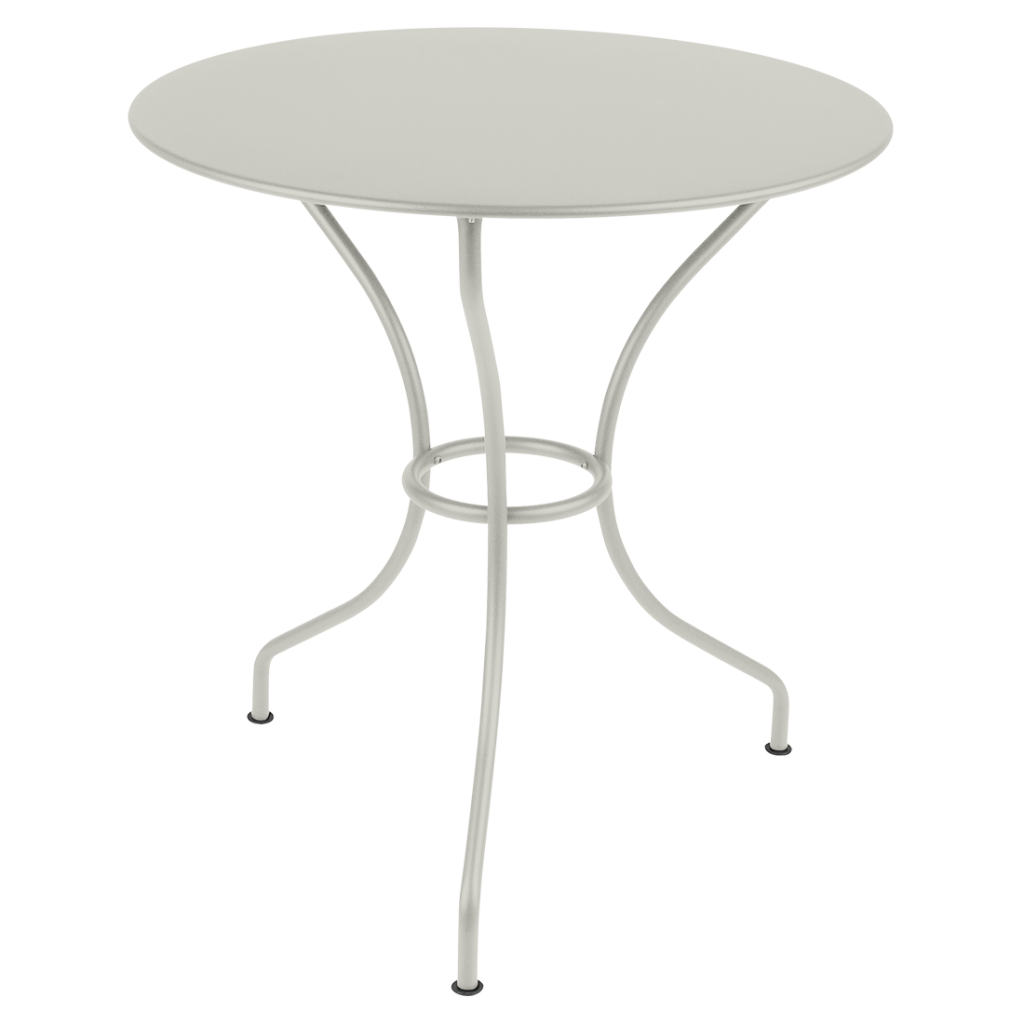 Une table ronde avec un piètement en métal blanc.
