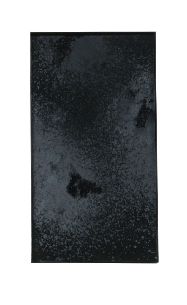 Un morceau de verre noir sur une surface blanche.