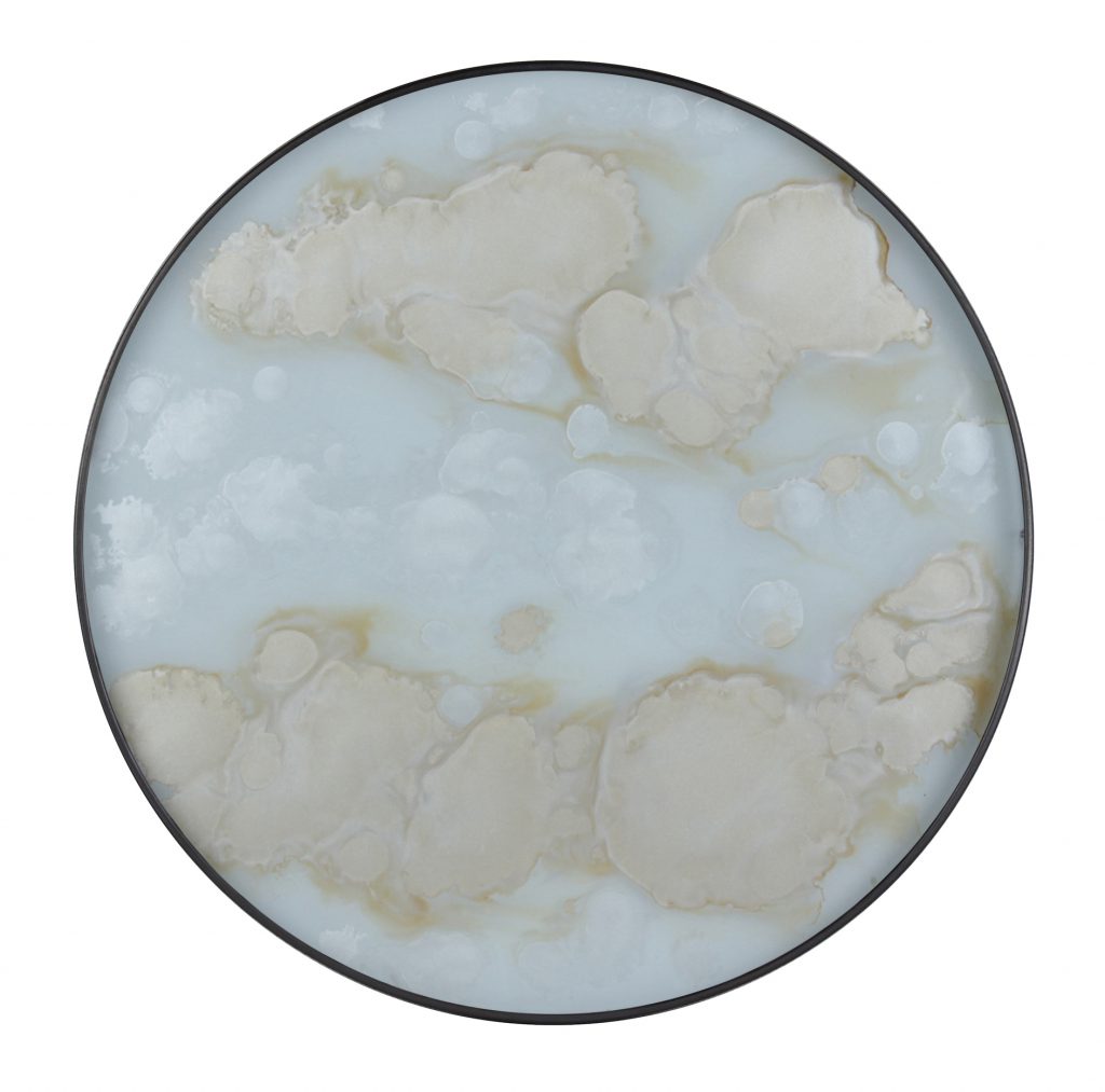 Une assiette ronde avec un motif blanc et beige.