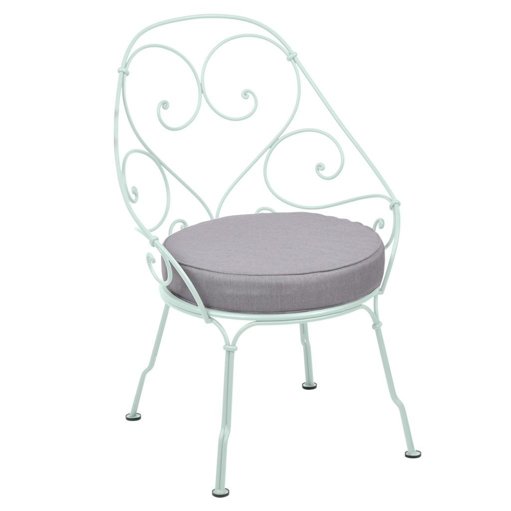 Une chaise en fer forgé blanc avec un coussin gris.