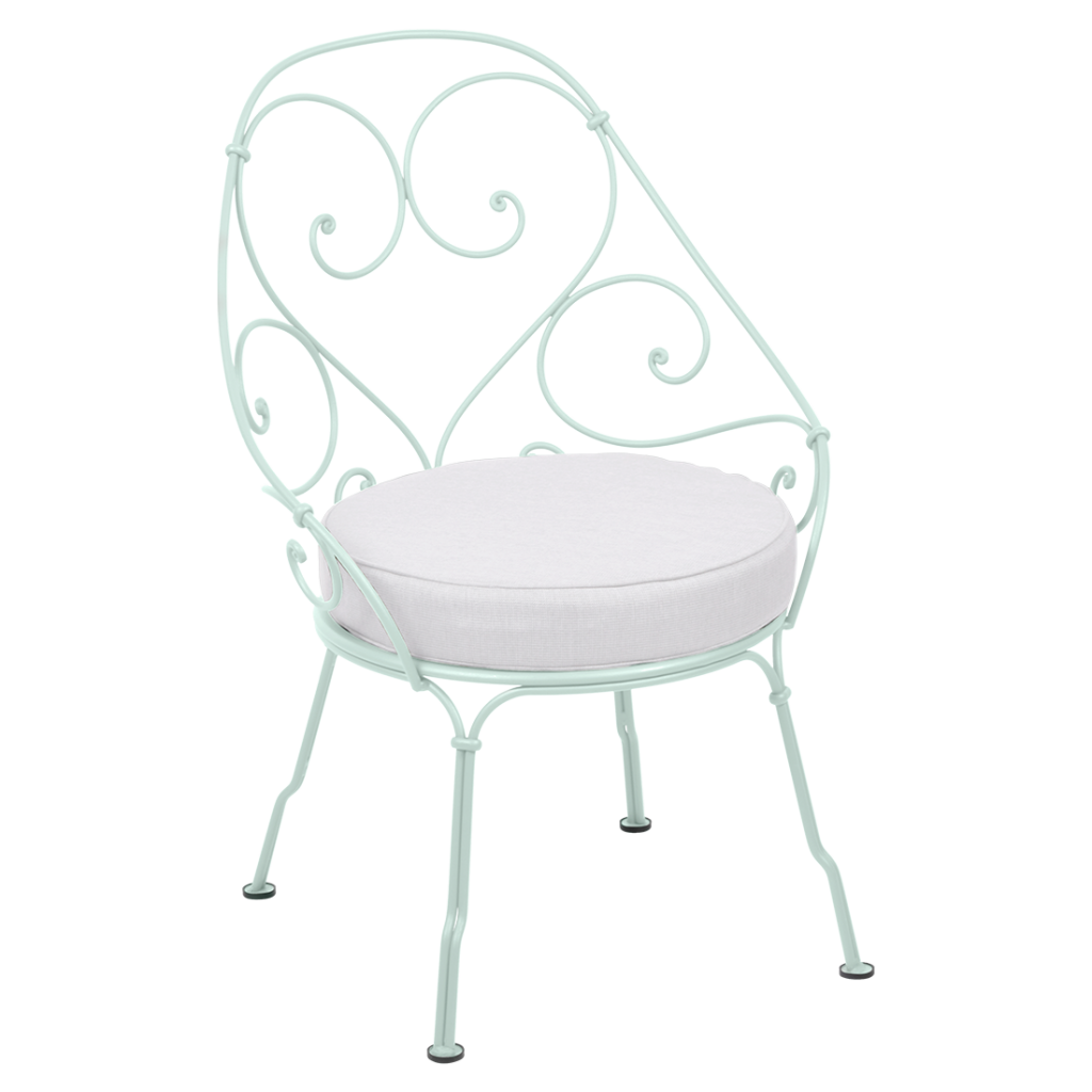 Une chaise en fer forgé avec un coussin blanc.