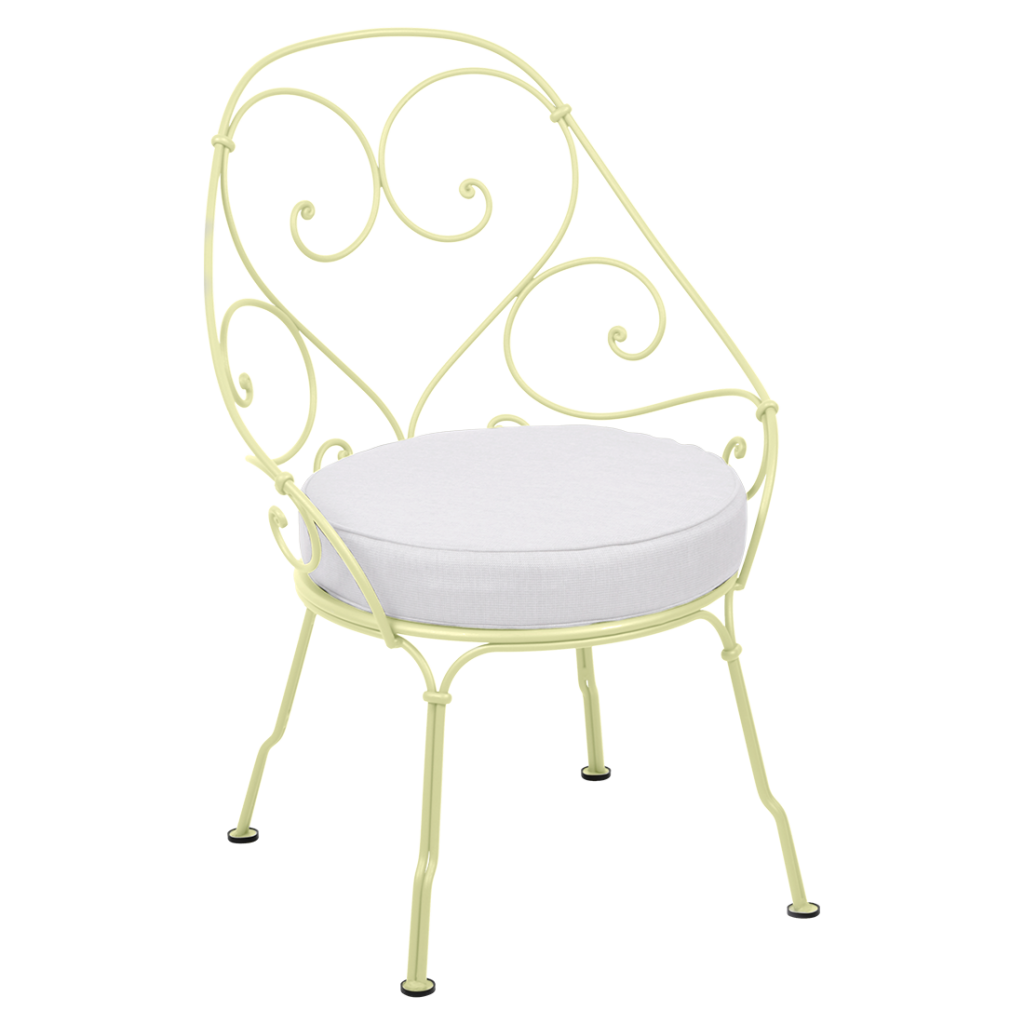 Une chaise en fer forgé jaune avec un coussin blanc.