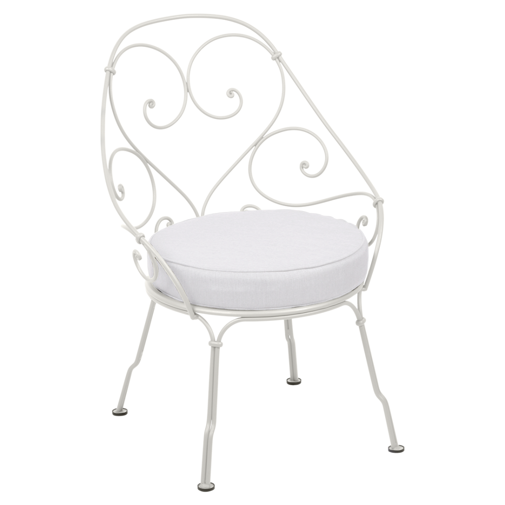 Une chaise en fer forgé blanc avec un coussin blanc.