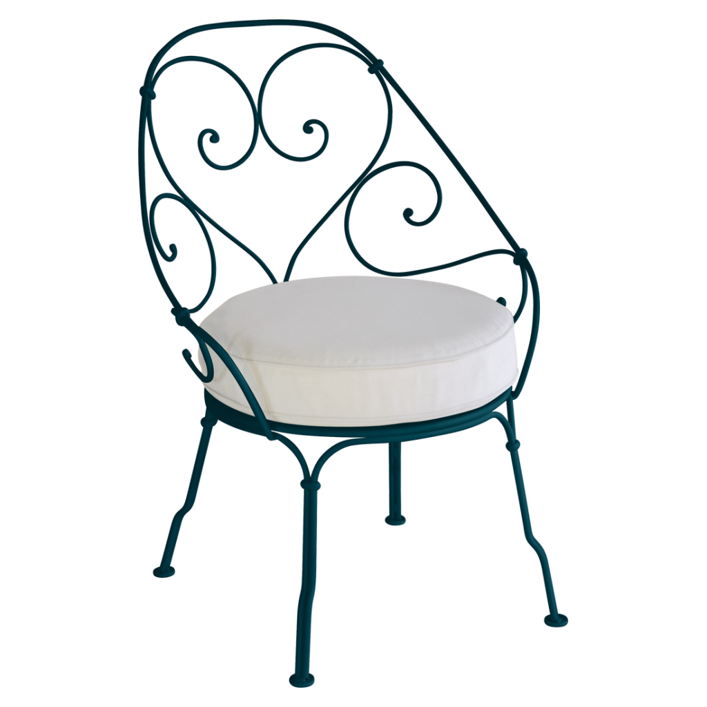 Une chaise en fer forgé avec un coussin blanc.