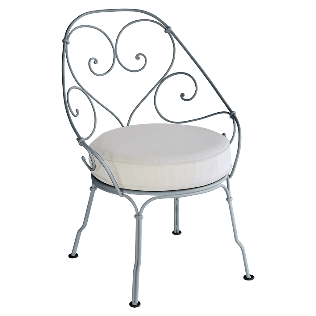 Une chaise en fer forgé avec un coussin blanc.