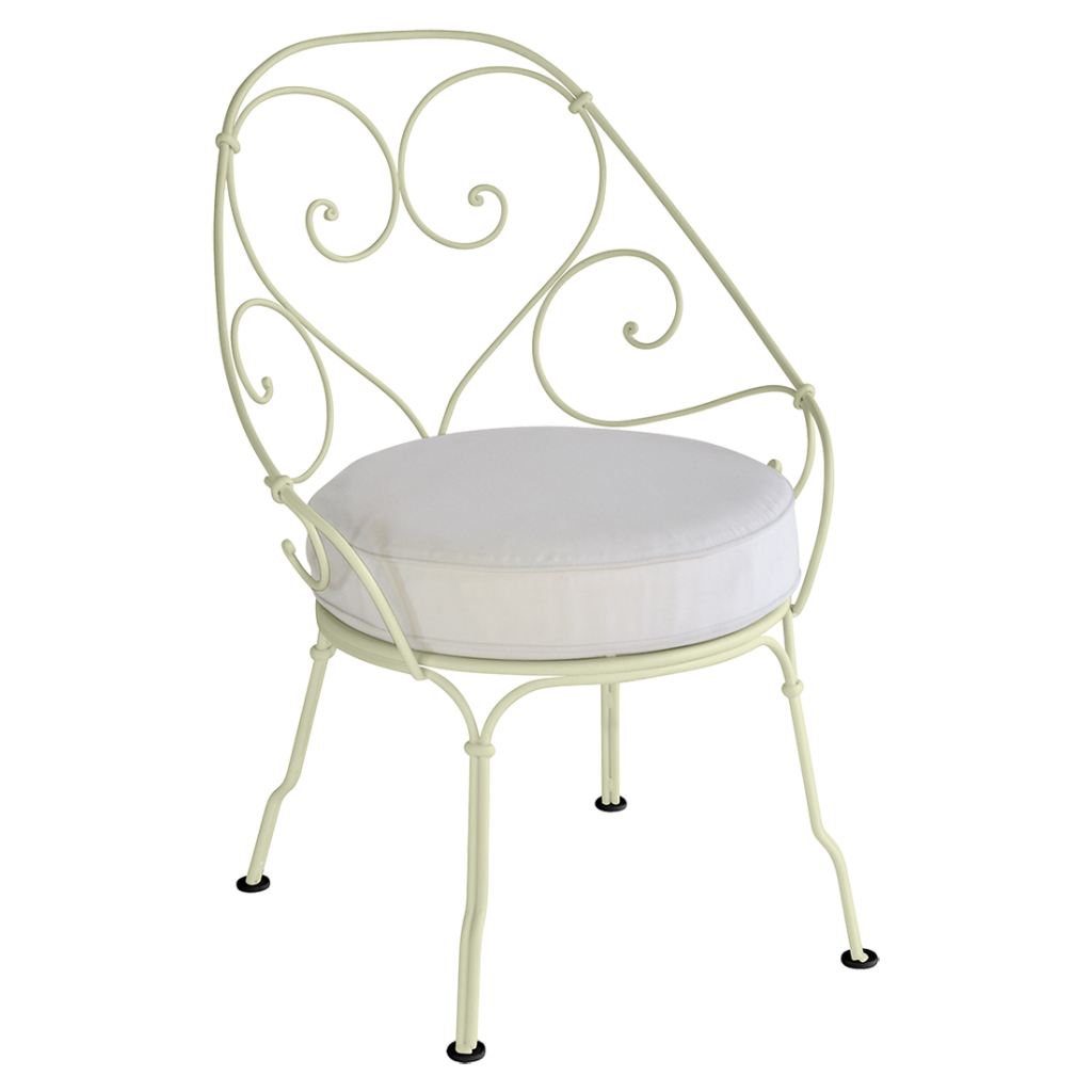 Une chaise en fer forgé avec un coussin blanc.