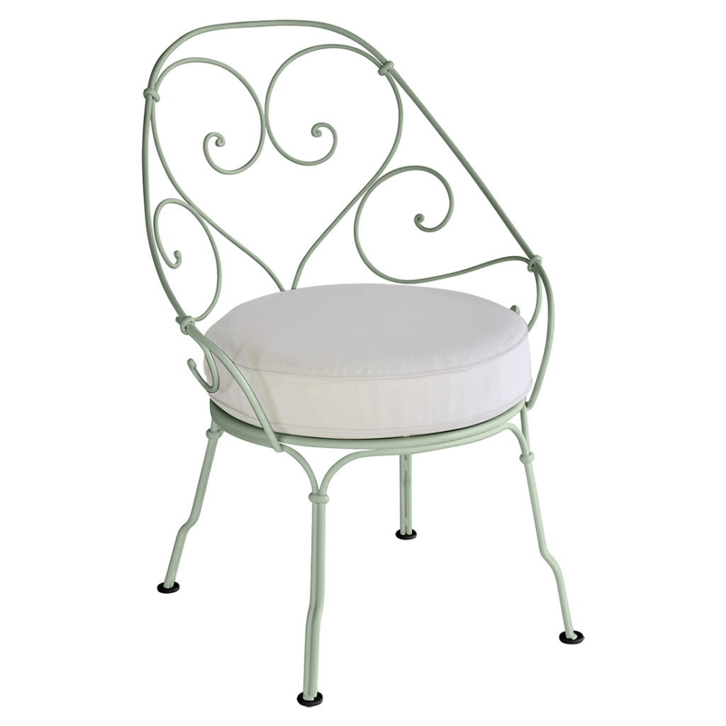 Une chaise en fer forgé vert avec un coussin blanc.