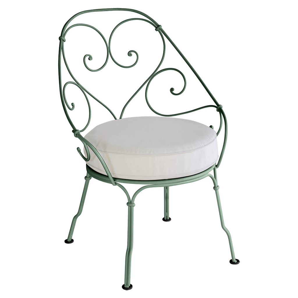 Une chaise en fer forgé vert avec un coussin blanc.