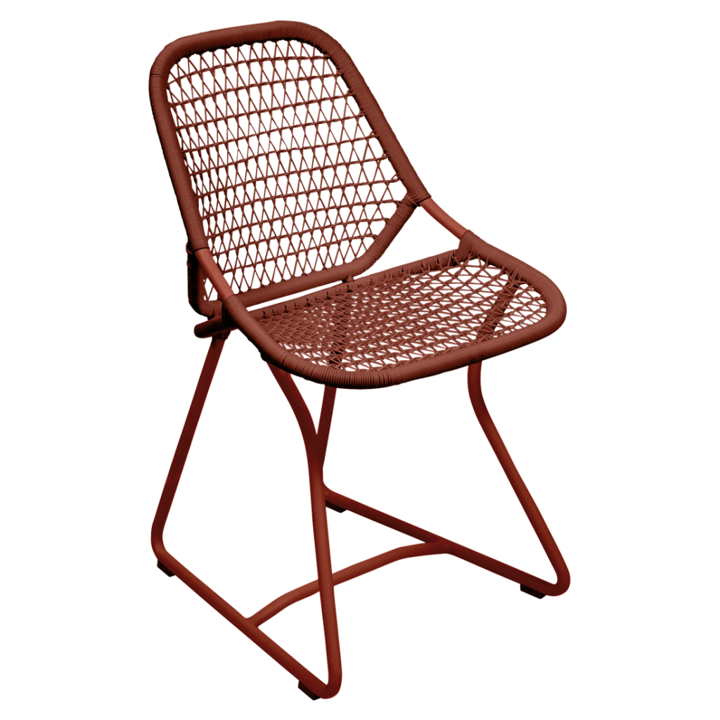 Une chaise en rotin rouge avec une structure en métal.