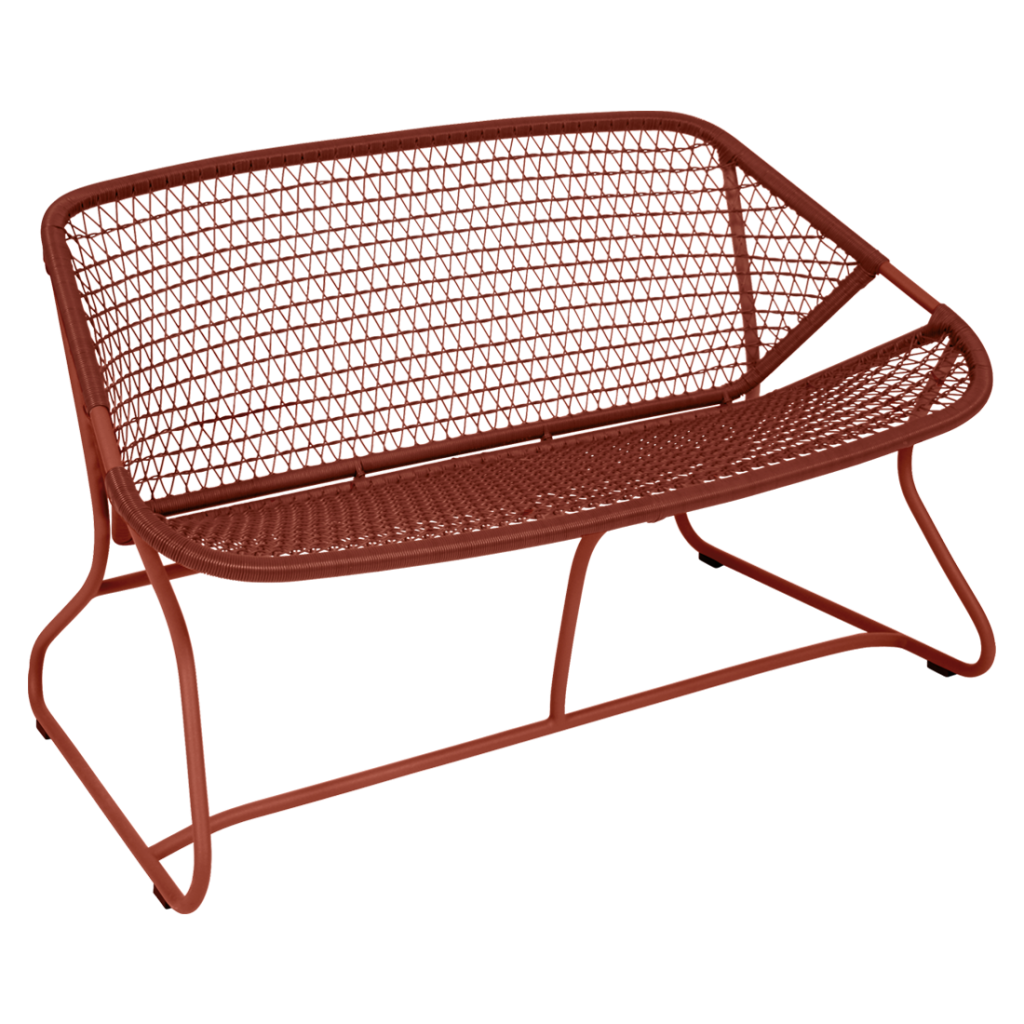 Un banc en osier rouge sur fond blanc.