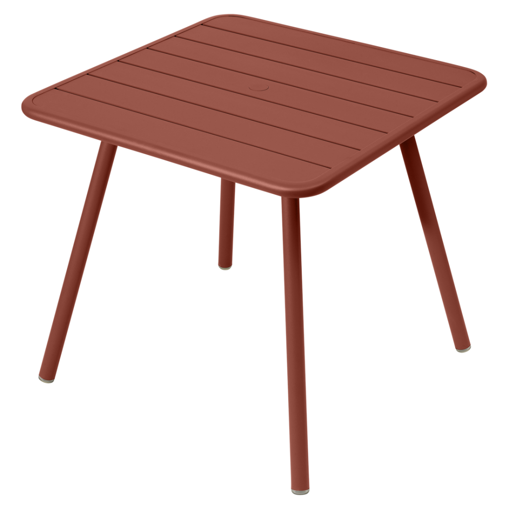 Une table d'extérieur aux pieds rouges.