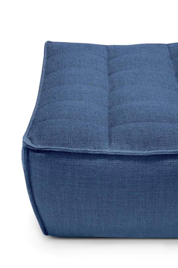 Gros plan sur un coussin de sol N701 bleu, de forme carrée, avec des coutures visibles et une surface en tissu texturé, parfait comme repose-pieds moderne.