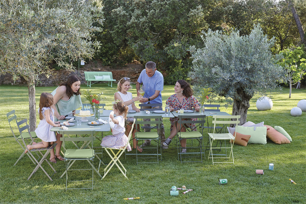 Un groupe de personnes assises autour d'une Table rectangulaire Bistro, 57 x 37 cm dans un jardin.