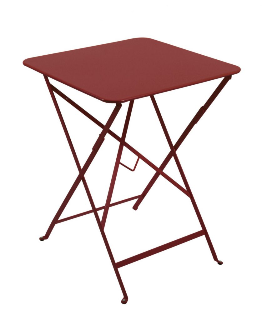 Une table pliante rouge sur fond blanc.