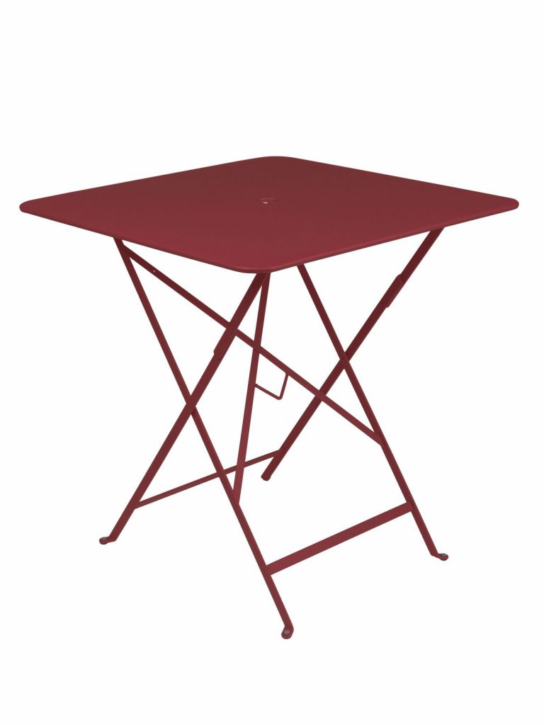 Une table pliante rouge sur fond blanc.