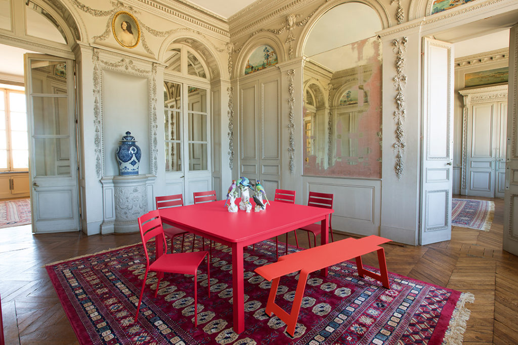 Table carree de jardin luxembourg craft en acier laque cataphorese couleur rose praline dans un chateau avec chaises et banc