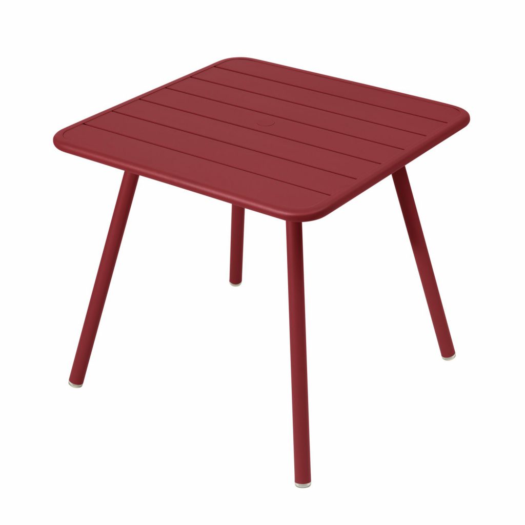 Une table d'extérieur avec des pieds rouges et un plateau carré.