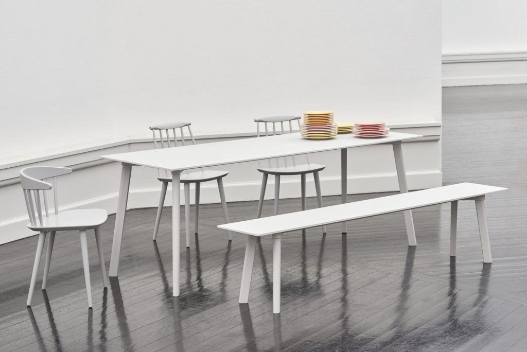 Une table à manger et des chaises blanches dans une pièce vide.