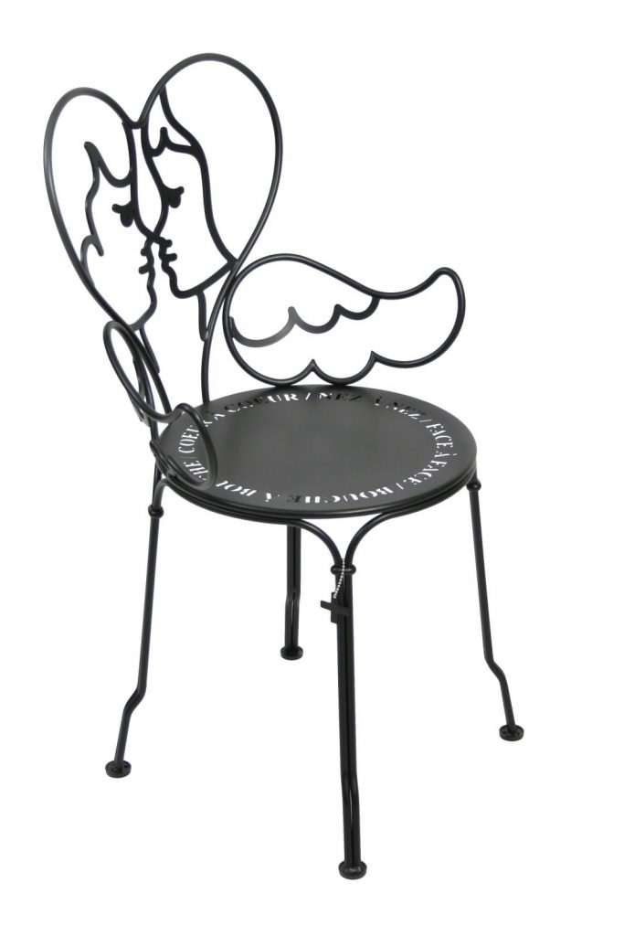 Une chaise en métal noir avec un cœur dessus.