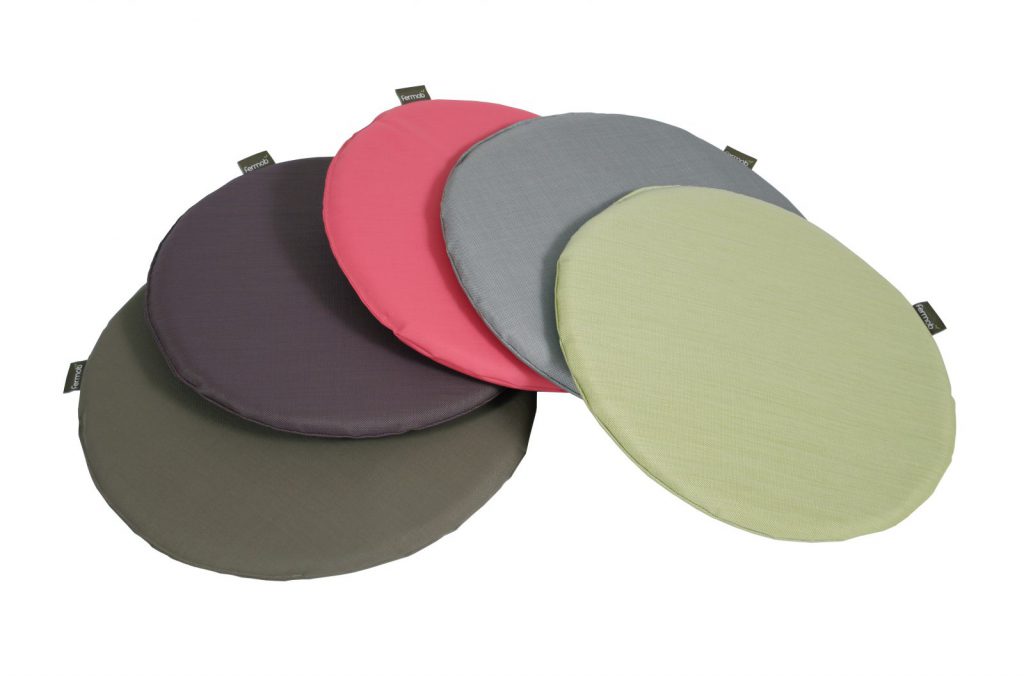 Quatre coussins ronds de couleurs différentes sur fond blanc.