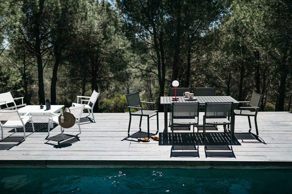 Une terrasse en bois avec une table et des chaises.