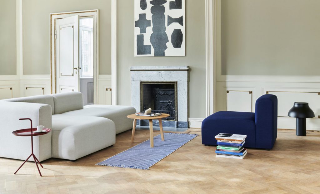 Un salon avec un canapé blanc et une chaise bleue.