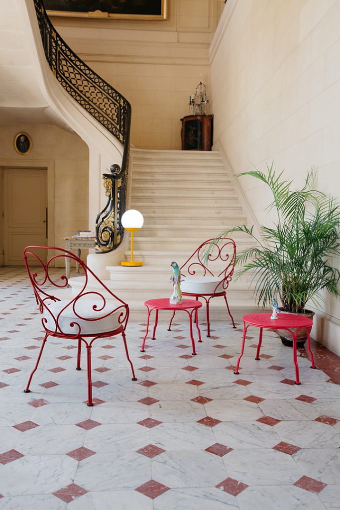 Une pièce avec des chaises rouges et un escalier.