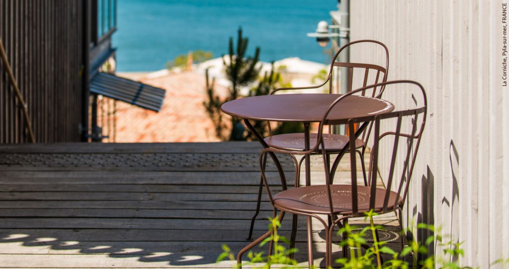 Une terrasse en bois avec une table et des chaises.