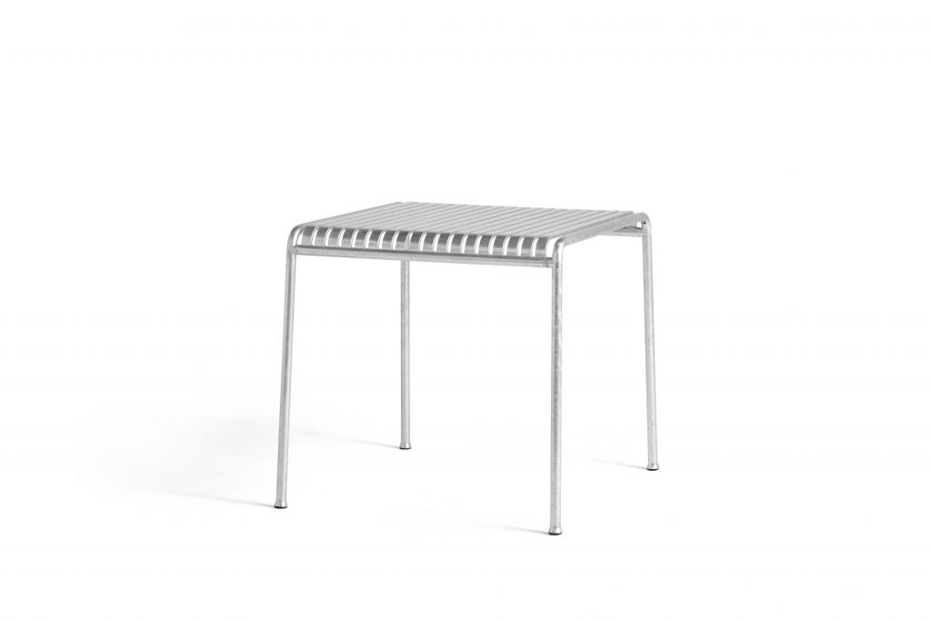 Une petite table avec une structure en métal sur fond blanc.