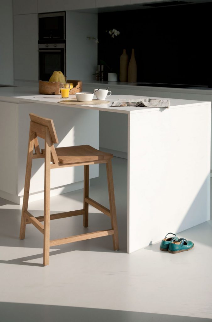 Une cuisine blanche avec une table et des chaises en bois.