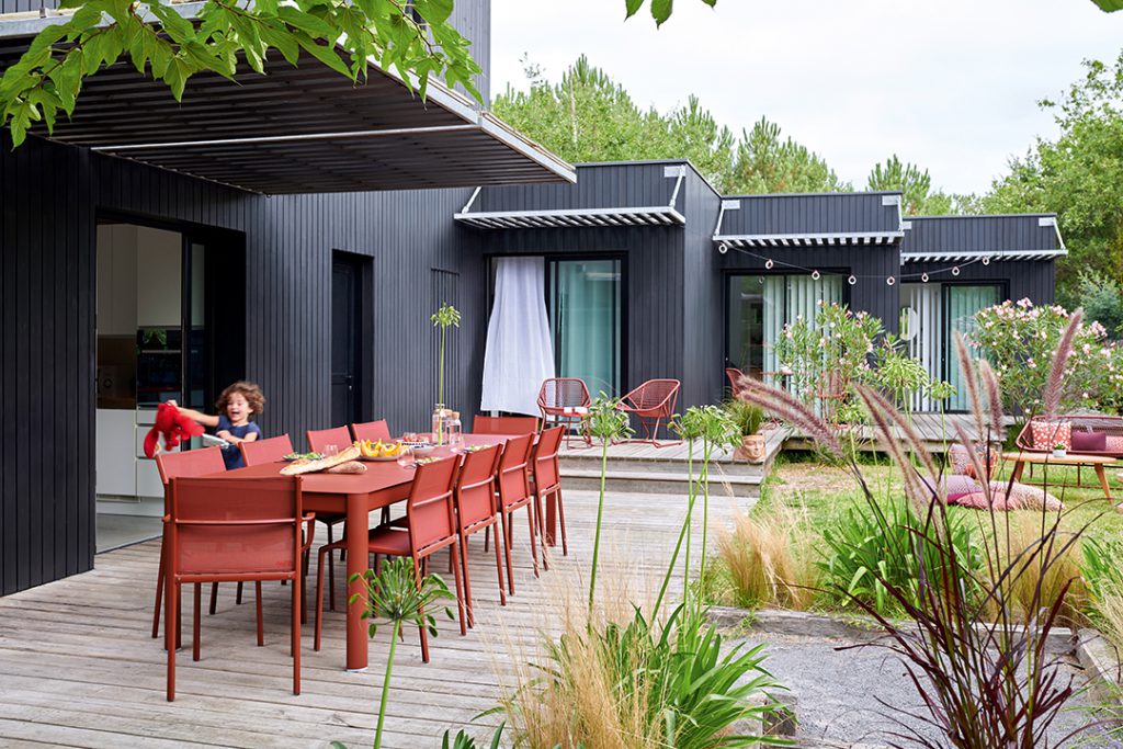 Personne assise à une table devant une maison.