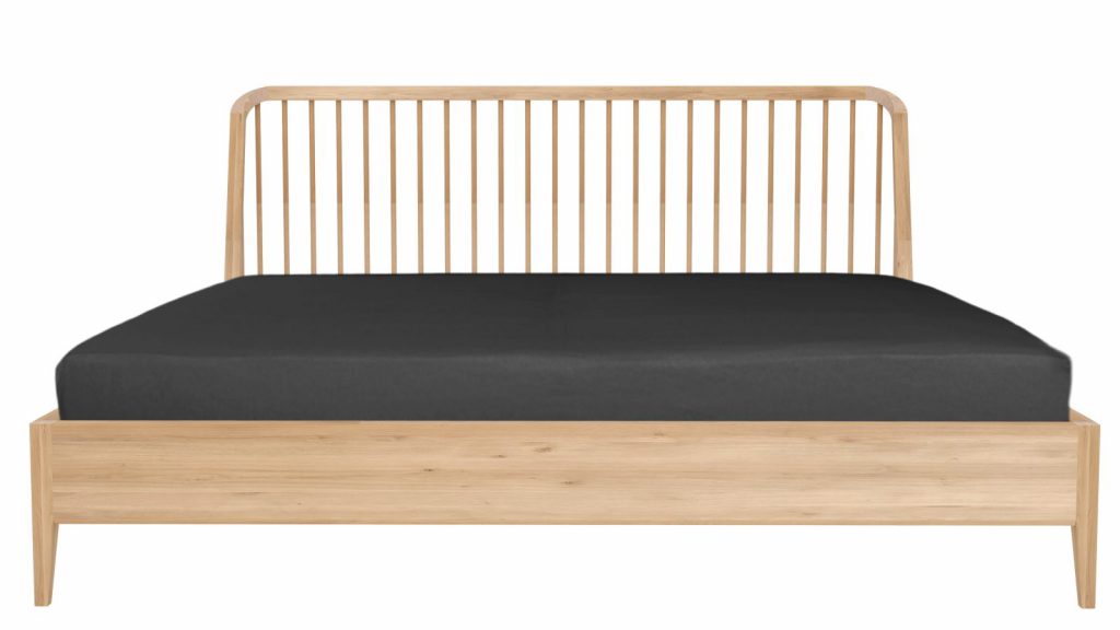 Un lit en bois avec un matelas et des lattes noires.