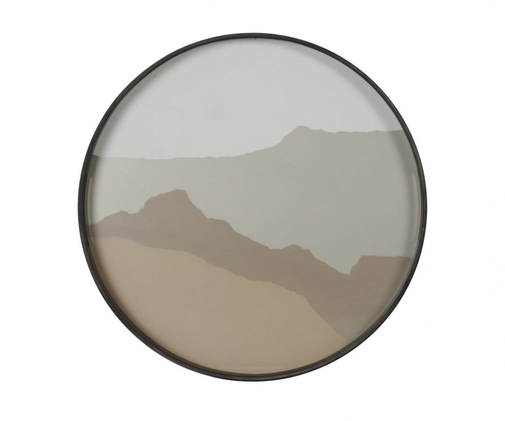 Un miroir rond avec des montagnes dessus.