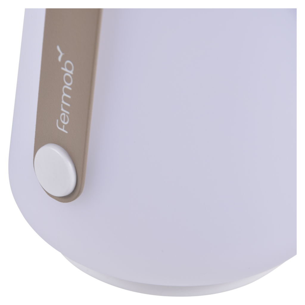 Une lampe blanche et dorée avec une poignée.