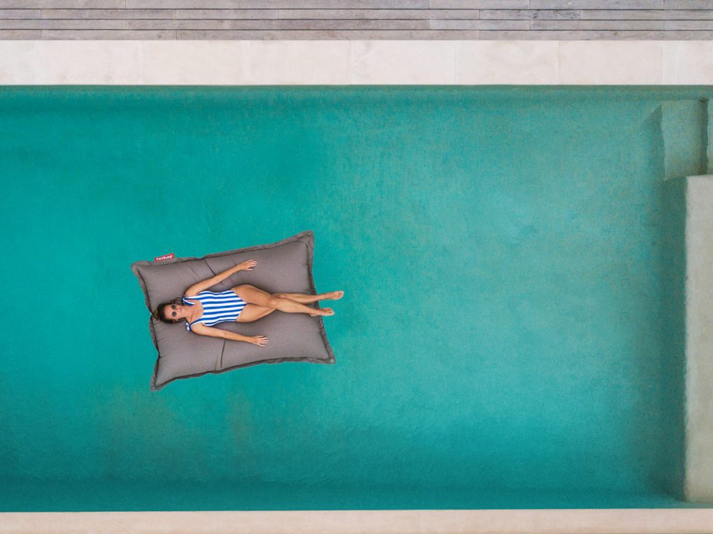 Une femme allongée dans une piscine avec un oreiller.