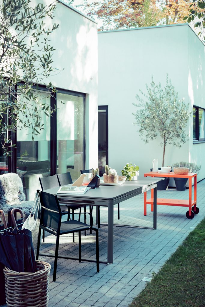 Un patio en brique avec une table et des chaises.
