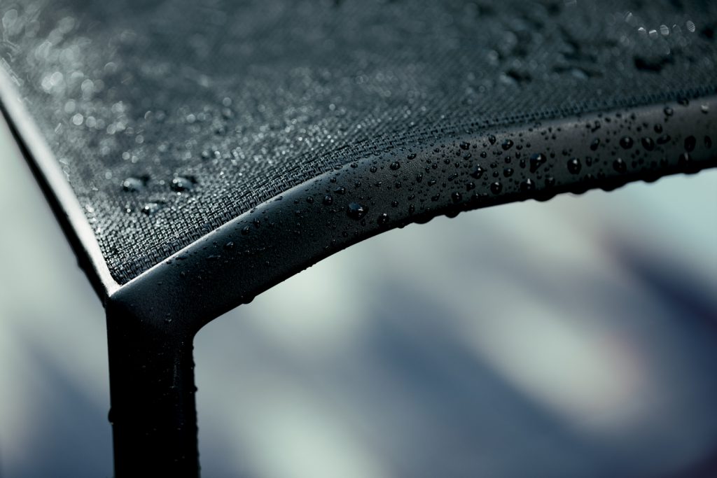 Un gros plan d'une voiture noire avec des gouttelettes d'eau dessus.