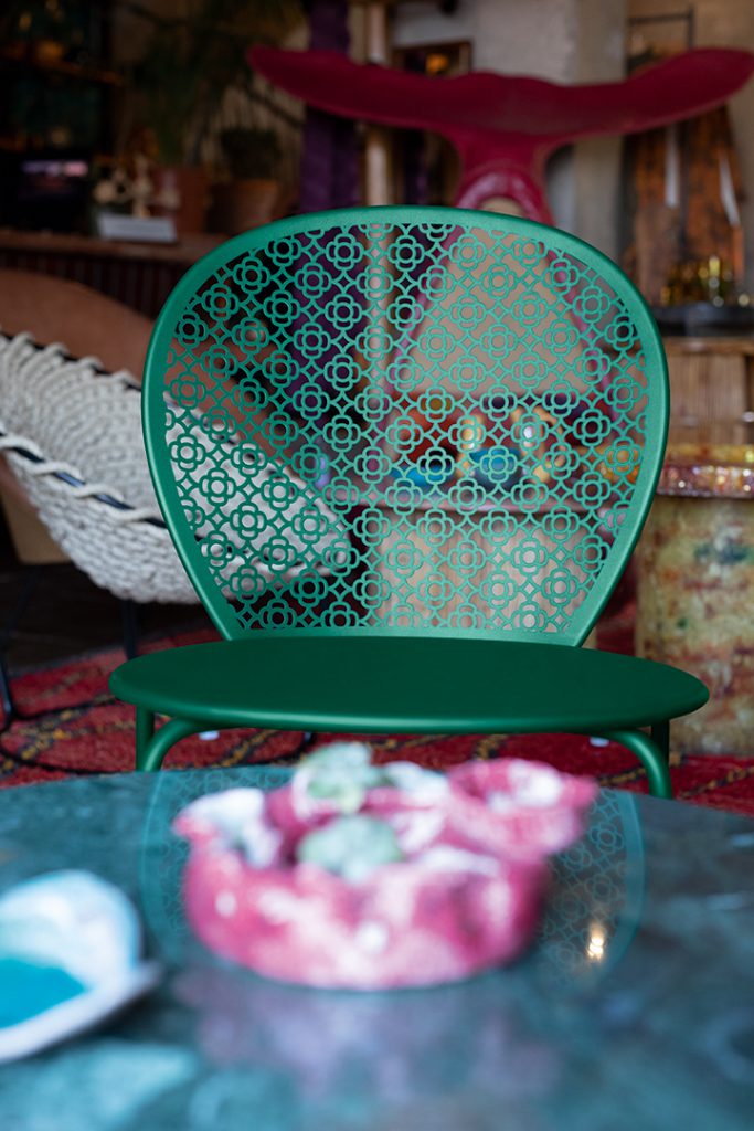 Une chaise verte est posée sur une table dans une pièce.