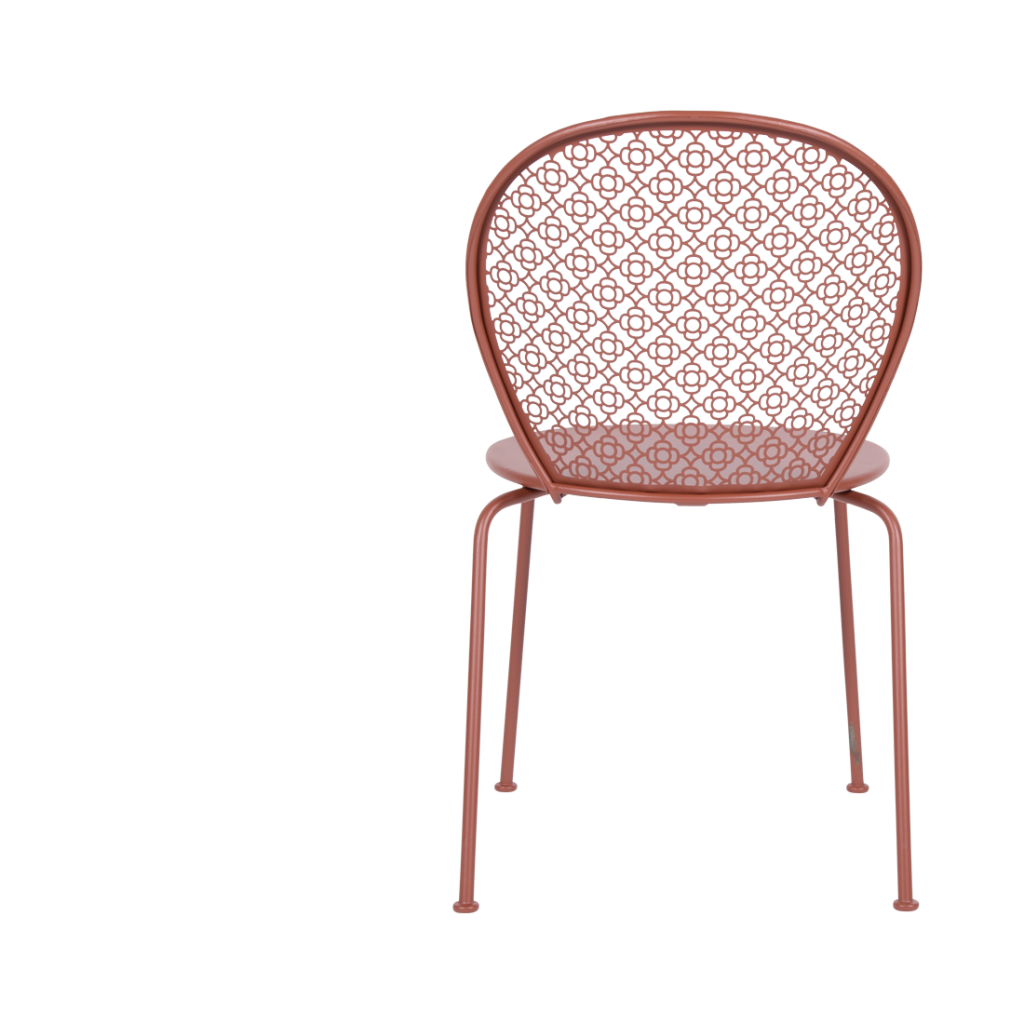 Une chaise en métal rouge avec un motif floral.