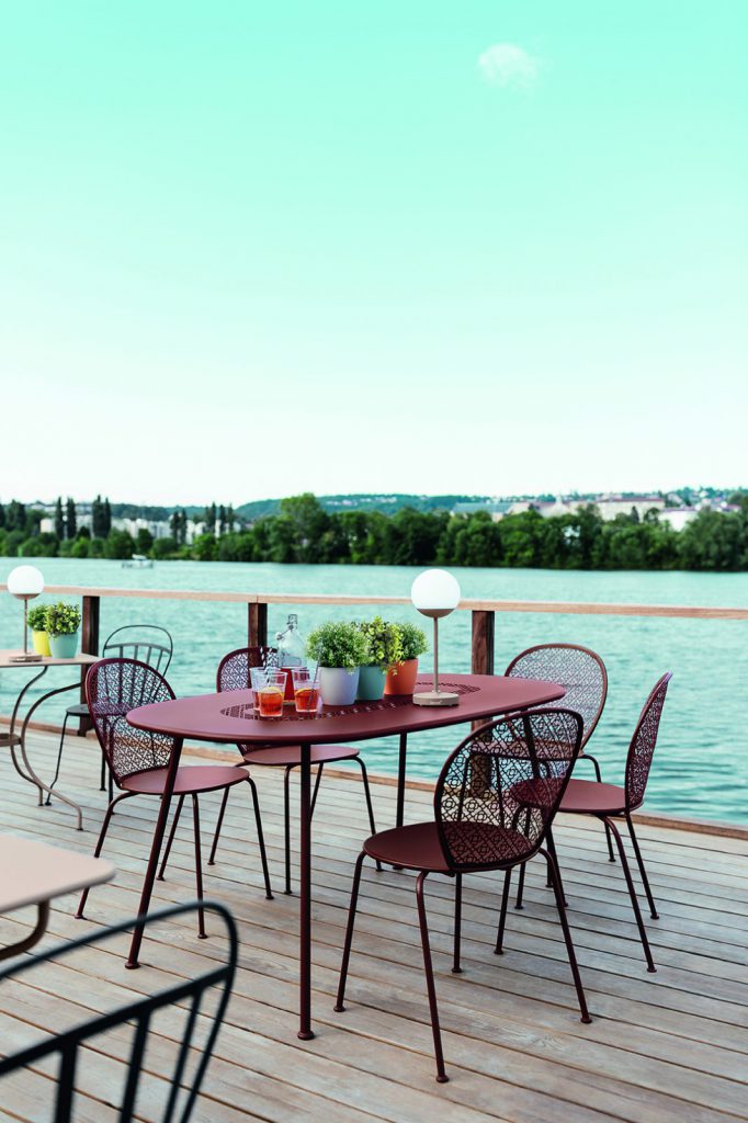 Une table et des chaises sur une terrasse surplombant un lac.