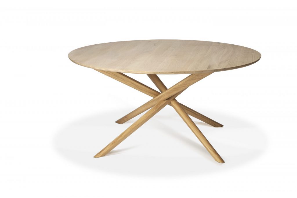Une table ronde avec une base en bois et des pieds croisés.