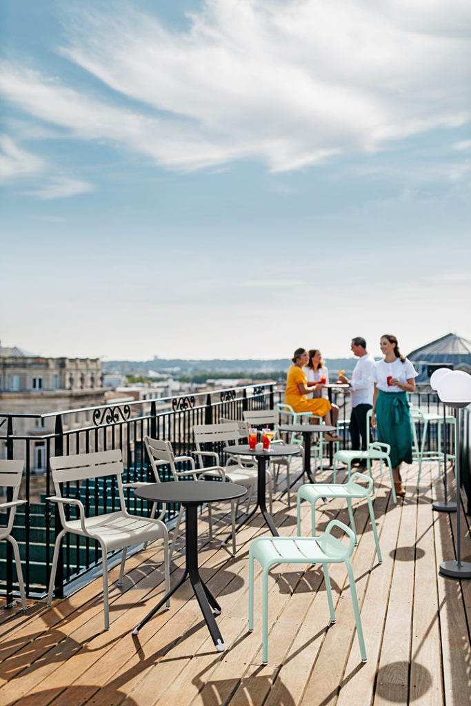 Tabourets bas et chaises de jardin luxembourg sur terrasse d'un hotel au soleil rooftop