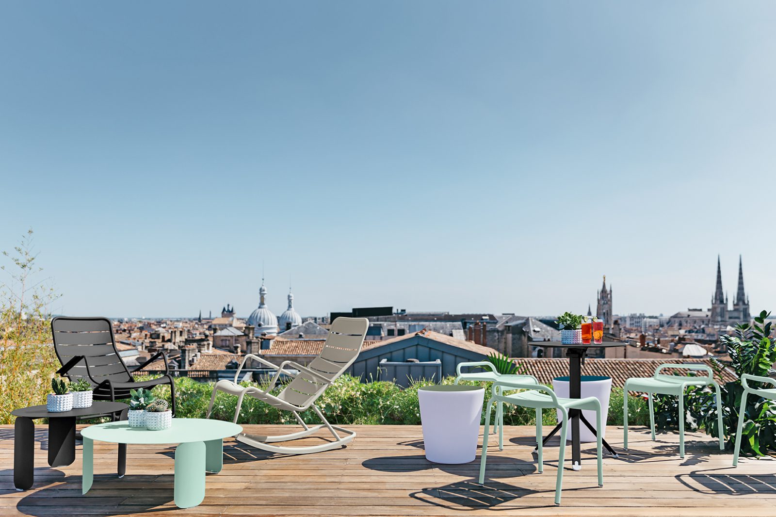 Tabourets bas et rocking chair de jardin luxembourg sur terrasse rooftop au soleil avec vue sur une ville bordeaux