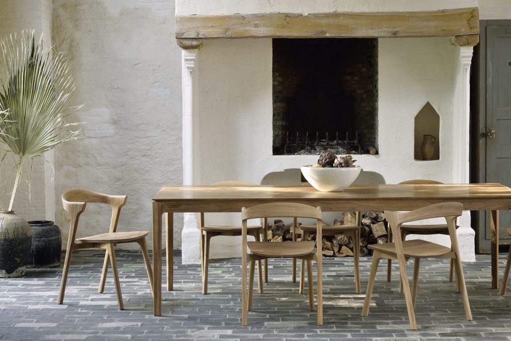 Une table à manger et des chaises en bois dans une pièce avec cheminée.