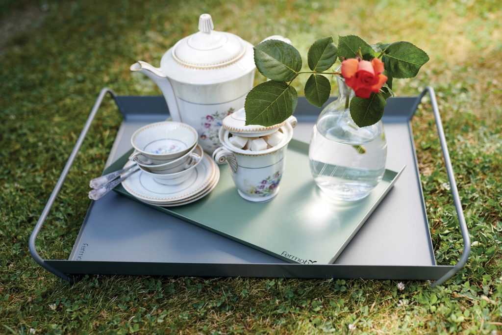 Un plateau avec du thé, du café et une rose dessus.