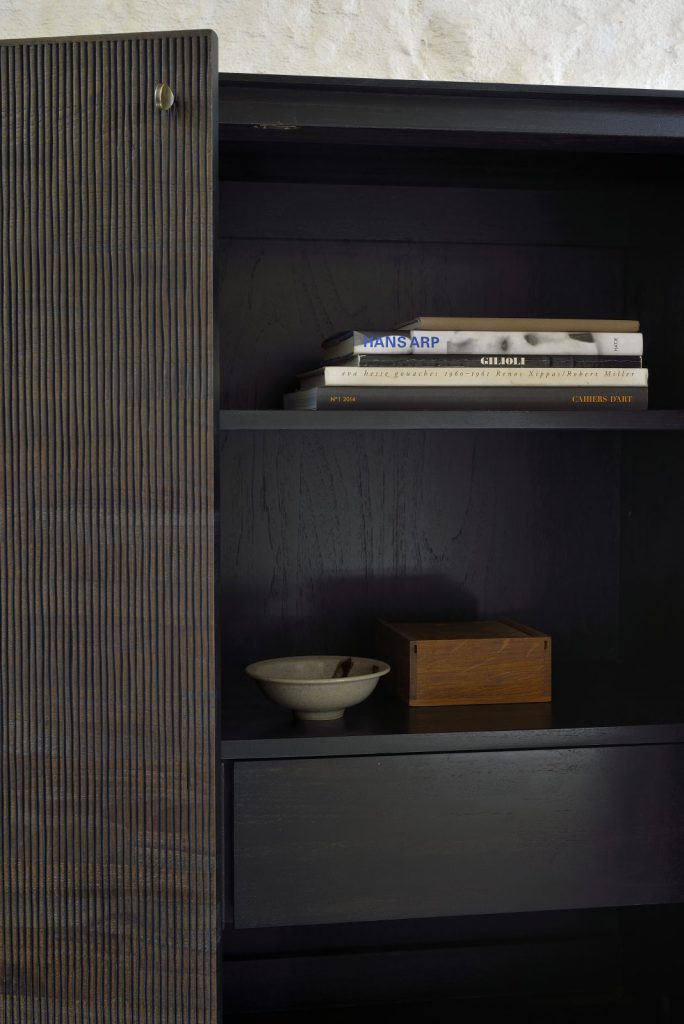 Une armoire noire avec des étagères et des livres.