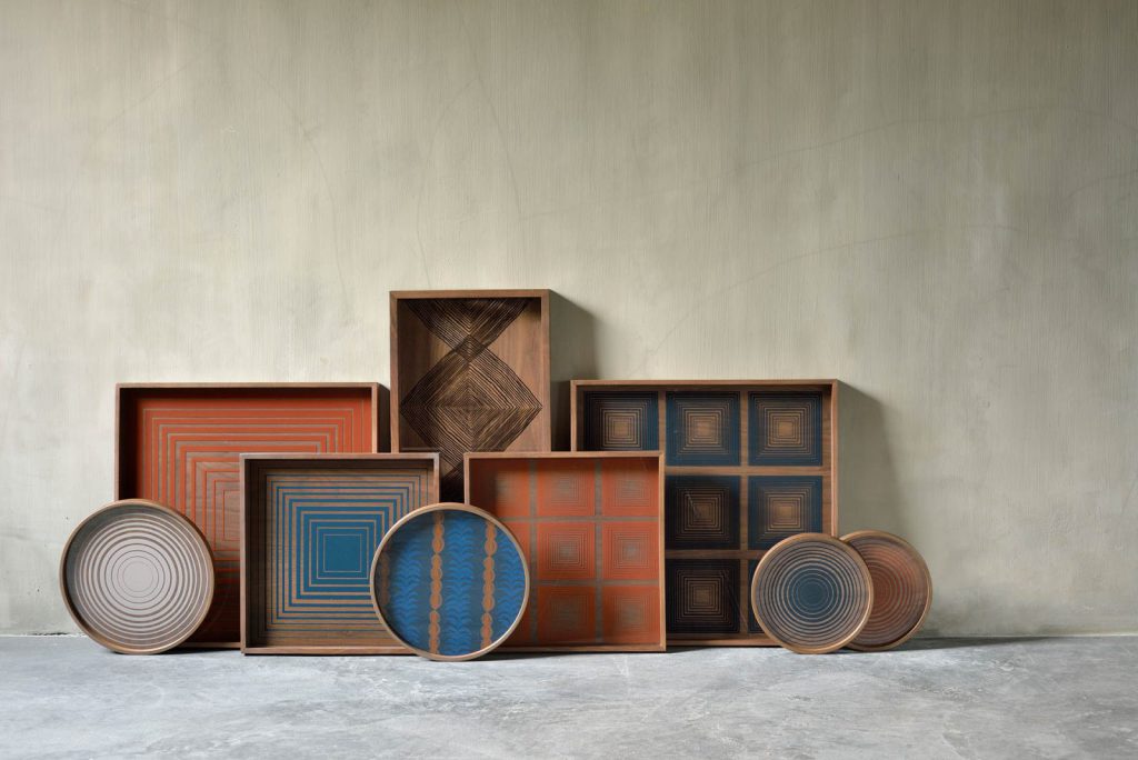 Un groupe de plateaux en bois avec différents motifs.