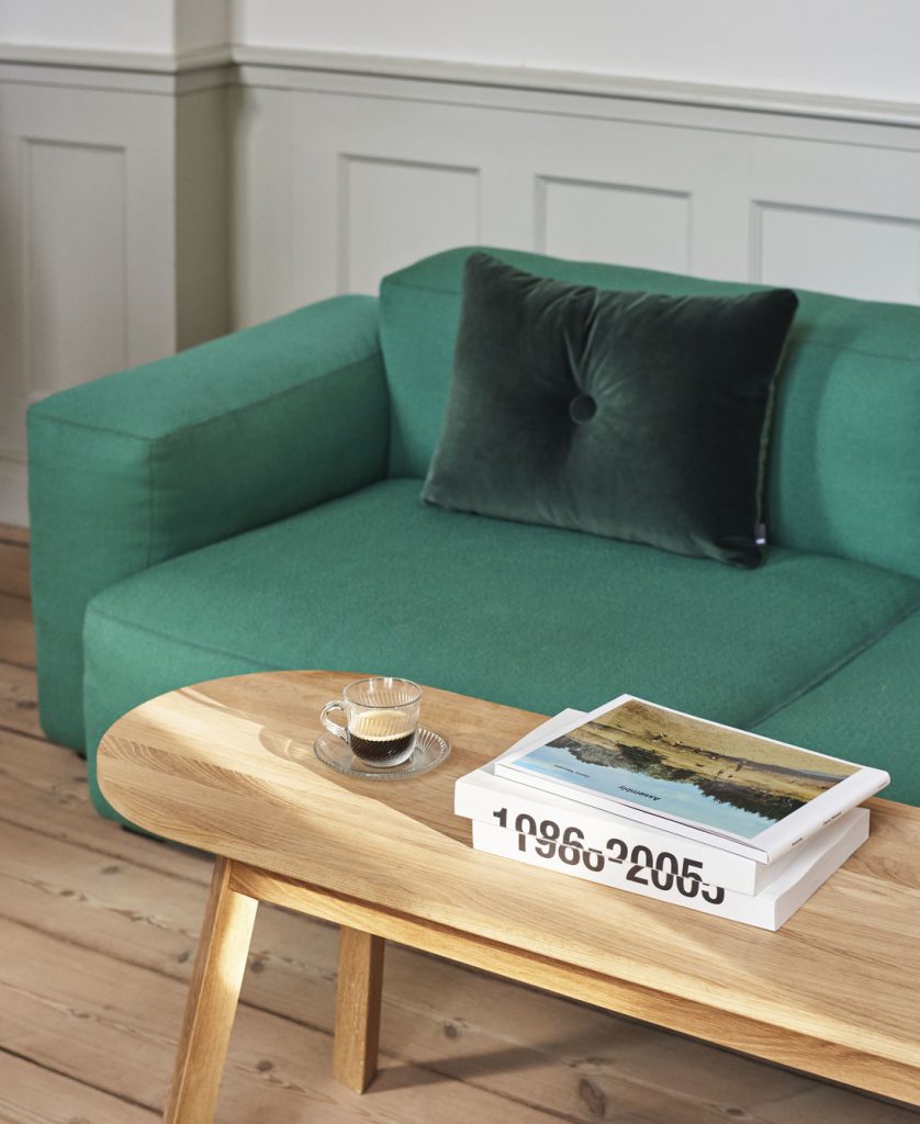 Un salon avec un canapé vert et une table basse.